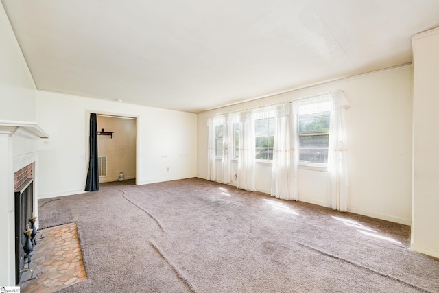 unfurnished living room featuring a fireplace with flush hearth, visible vents, baseboards, and carpet floors
