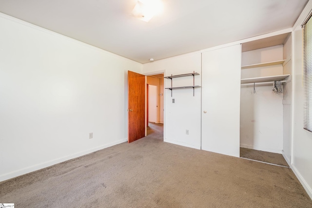 unfurnished bedroom featuring a closet, baseboards, and carpet flooring
