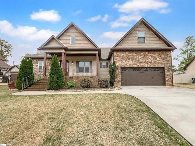 craftsman-style house with a garage, a front yard, a porch, and driveway