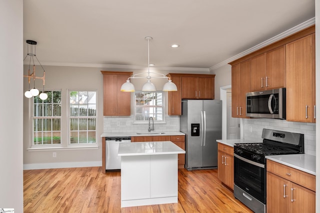 kitchen featuring light countertops, crown molding, a sink, and stainless steel appliances