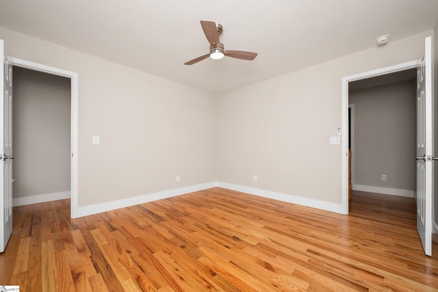 unfurnished bedroom with light wood-style flooring, baseboards, and a ceiling fan