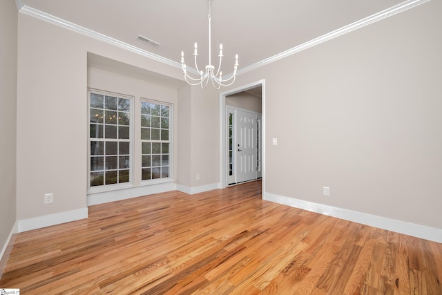unfurnished room featuring baseboards, ornamental molding, a chandelier, visible vents, and wood finished floors