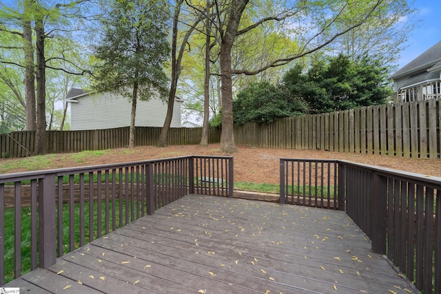 wooden terrace with a fenced backyard