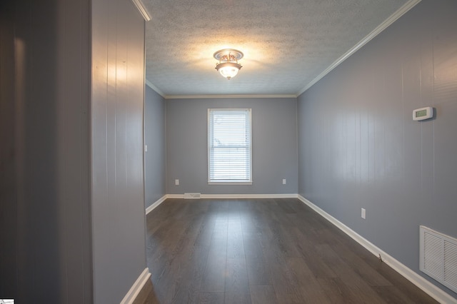 unfurnished room with visible vents, dark wood-style flooring, ornamental molding, and a textured ceiling