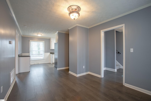 empty room with dark wood finished floors, a textured ceiling, ornamental molding, stairway, and baseboards