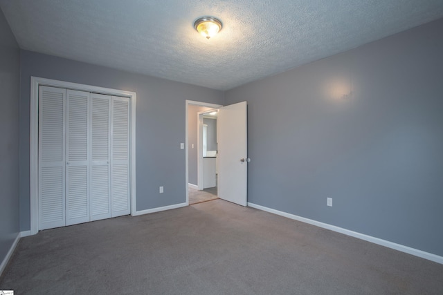unfurnished bedroom featuring a closet, baseboards, carpet flooring, and a textured ceiling