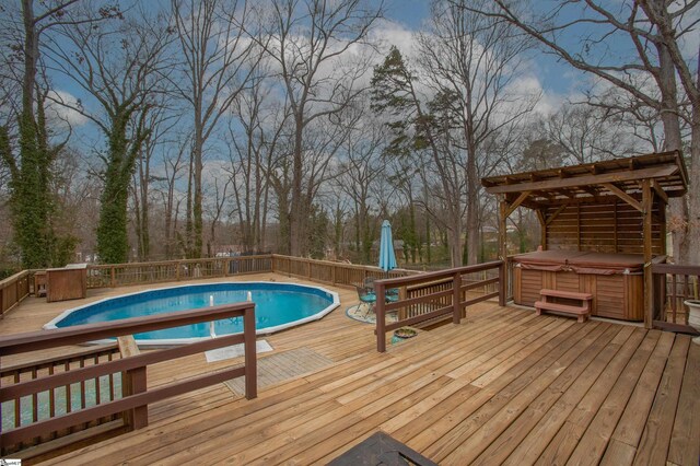view of swimming pool featuring a fenced in pool, a deck, and a hot tub