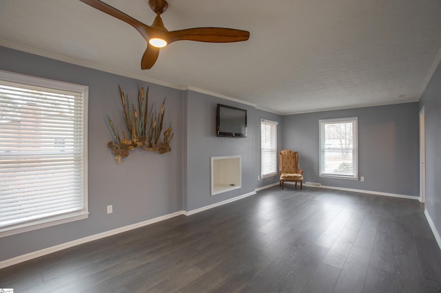unfurnished room with crown molding, baseboards, a ceiling fan, and dark wood-style flooring