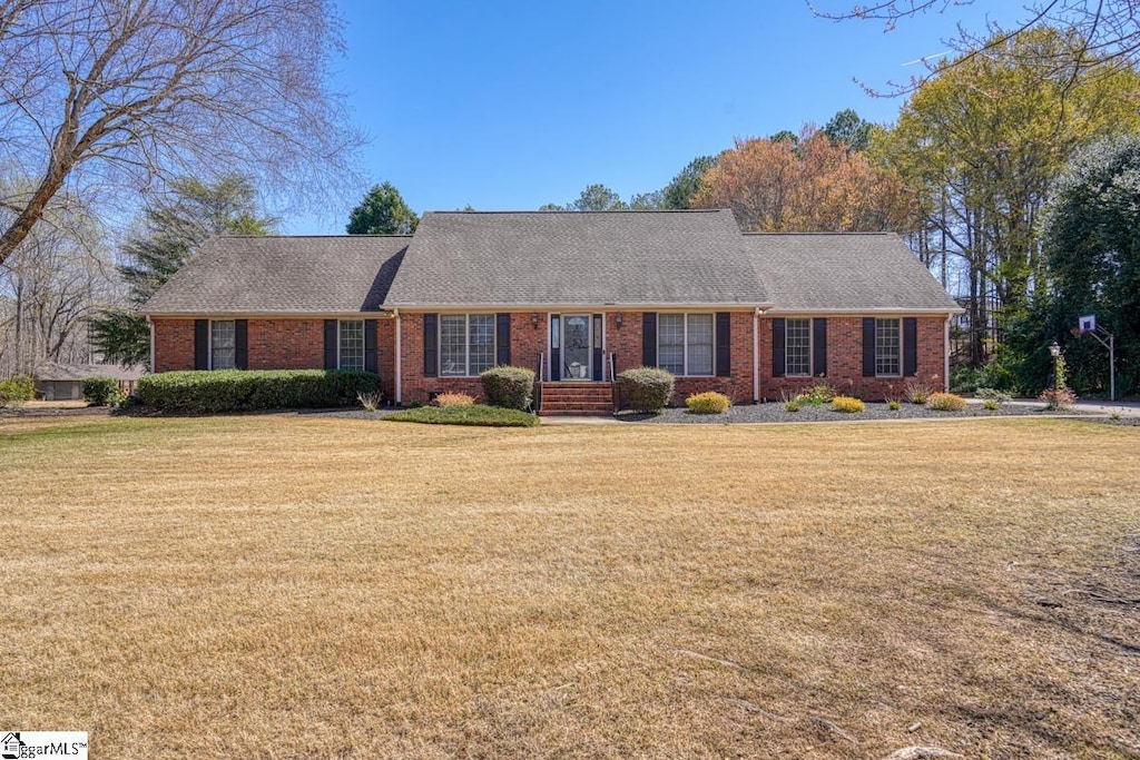 view of front of property with brick siding and a front lawn