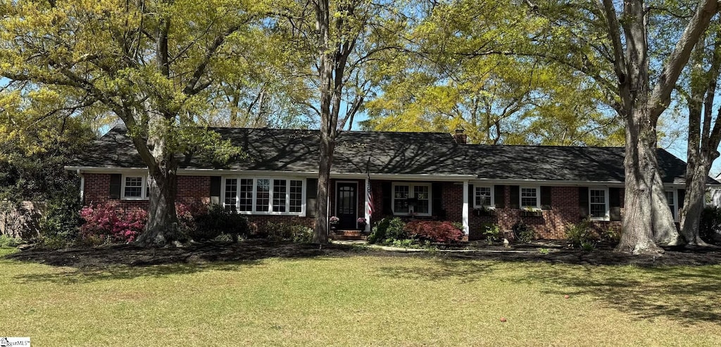 ranch-style house featuring a front yard and brick siding