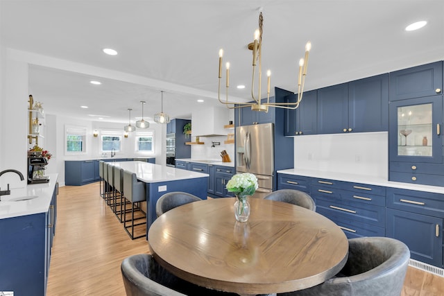 dining area with a chandelier, recessed lighting, and light wood-type flooring