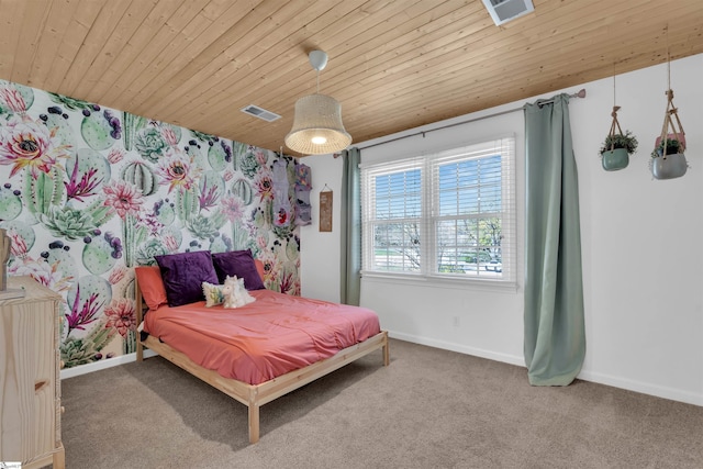 carpeted bedroom featuring visible vents, baseboards, and wooden ceiling