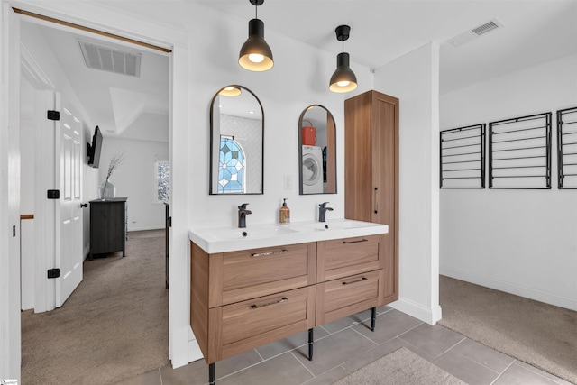 bathroom featuring tile patterned floors, double vanity, baseboards, and visible vents