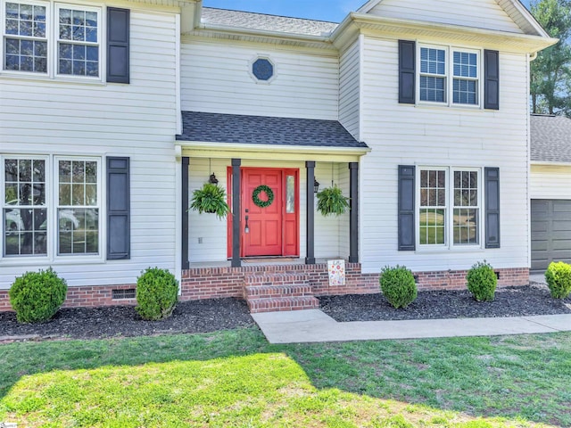 traditional home with a front yard, a shingled roof, a garage, and crawl space