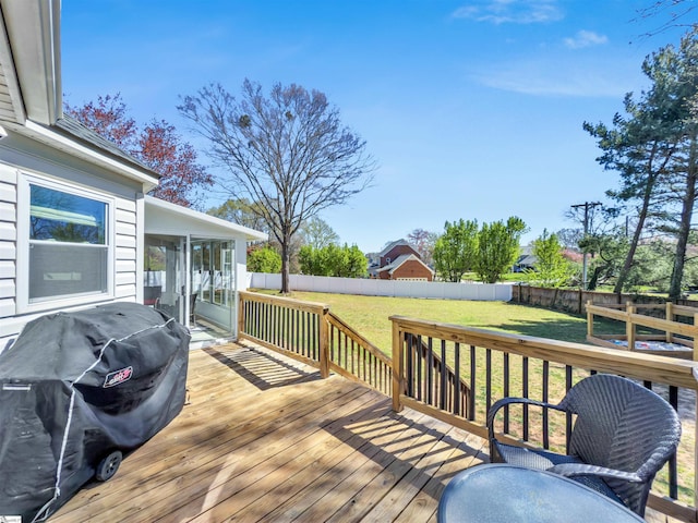 wooden deck featuring a yard, a fenced backyard, and grilling area
