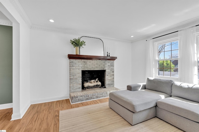 living room featuring ornamental molding, light wood-style flooring, and baseboards