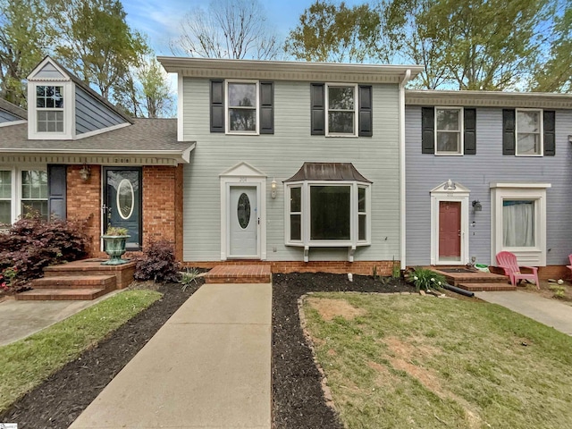 view of front of house featuring a front yard and roof with shingles