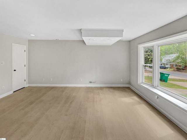 spare room with light wood-style floors and baseboards