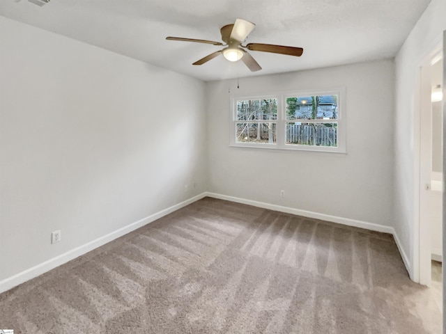 unfurnished room featuring carpet flooring, baseboards, and a ceiling fan