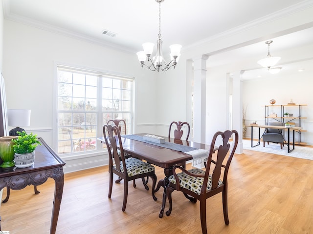dining room with light wood-style floors, visible vents, crown molding, and a chandelier