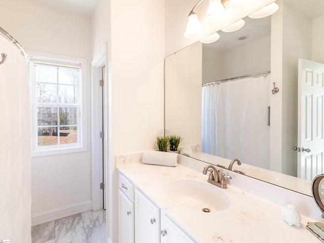 bathroom featuring baseboards, marble finish floor, and vanity
