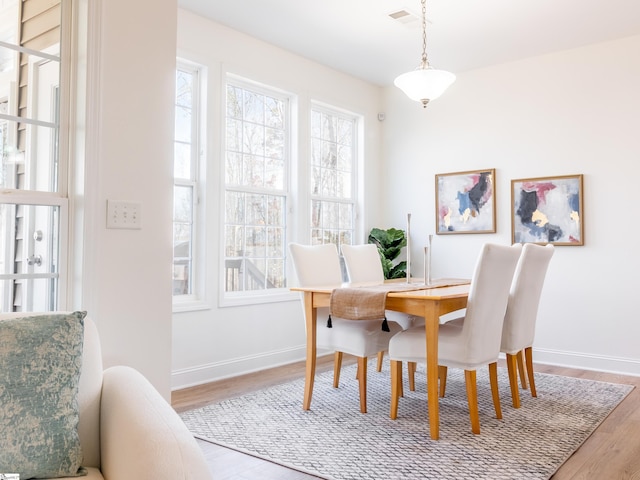dining room featuring visible vents, baseboards, and wood finished floors