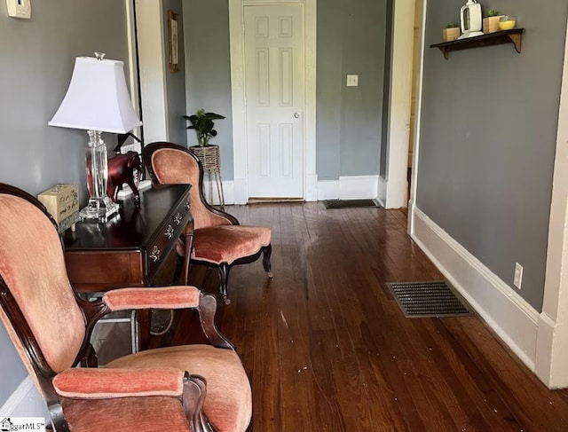 living area featuring hardwood / wood-style floors, baseboards, and visible vents