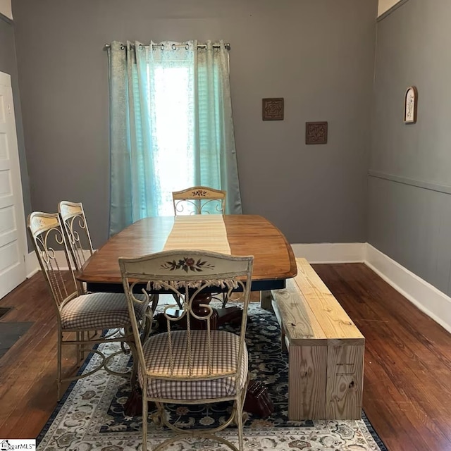 dining area with baseboards and wood finished floors