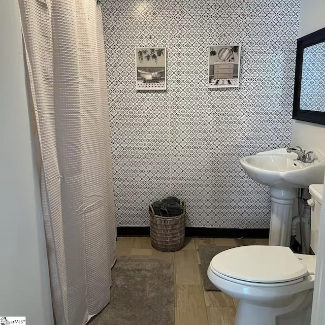 bathroom with toilet, a sink, a shower with shower curtain, and tile walls