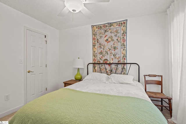 bedroom featuring ceiling fan, carpet, baseboards, and a textured ceiling