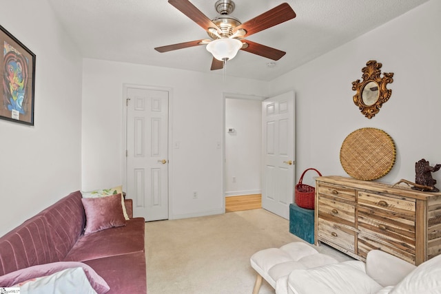 carpeted living room with ceiling fan and baseboards