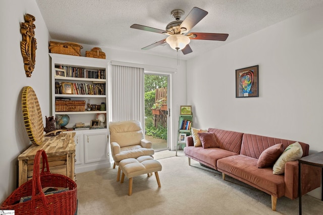 sitting room featuring a textured ceiling, a ceiling fan, and carpet