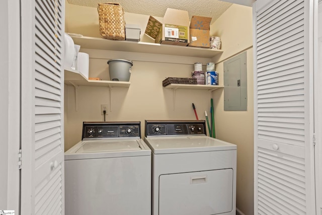 laundry area with electric panel, washer and dryer, laundry area, and a textured ceiling