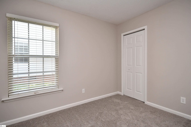 empty room featuring baseboards and carpet