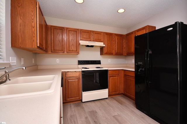 kitchen with brown cabinets, range with electric cooktop, black fridge with ice dispenser, and under cabinet range hood