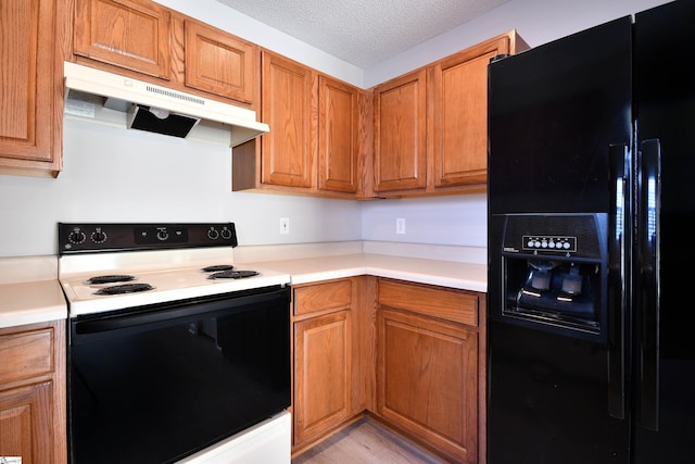 kitchen with a textured ceiling, under cabinet range hood, light countertops, range with electric stovetop, and black fridge with ice dispenser