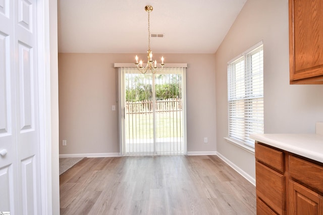 unfurnished dining area featuring a notable chandelier, visible vents, light wood-type flooring, and vaulted ceiling