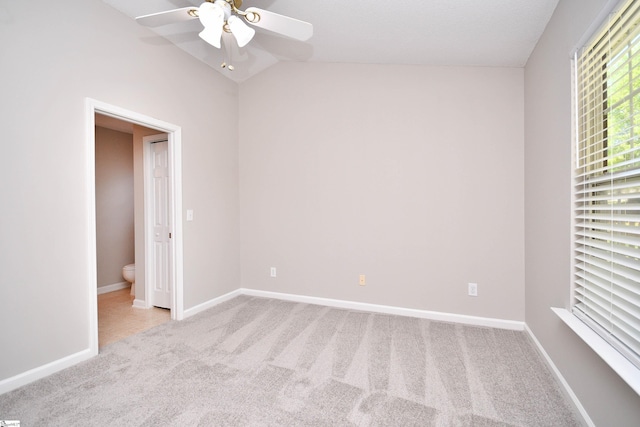 unfurnished room with carpet flooring, ceiling fan, lofted ceiling, and baseboards