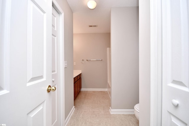 full bath featuring vanity, visible vents, baseboards, and toilet