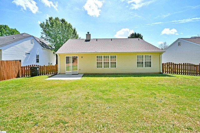 back of property with a patio area, a fenced backyard, a lawn, and a chimney