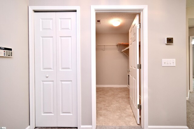 walk in closet with light tile patterned floors