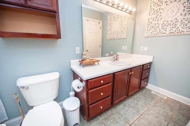 bathroom featuring visible vents, baseboards, toilet, vanity, and tile patterned flooring