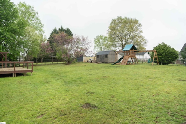 view of yard featuring a shed, a fenced backyard, a playground, and an outdoor structure