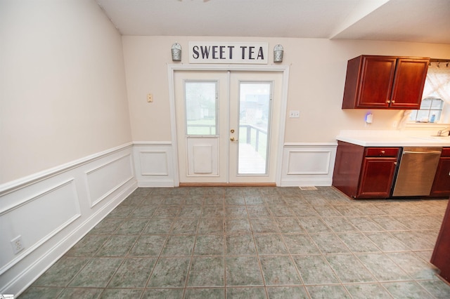 kitchen with a decorative wall, dishwasher, light countertops, and wainscoting