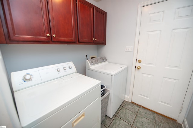 laundry room with cabinet space, light tile patterned floors, and washing machine and dryer