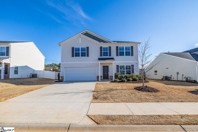 view of front of home with central AC, an attached garage, fence, and driveway
