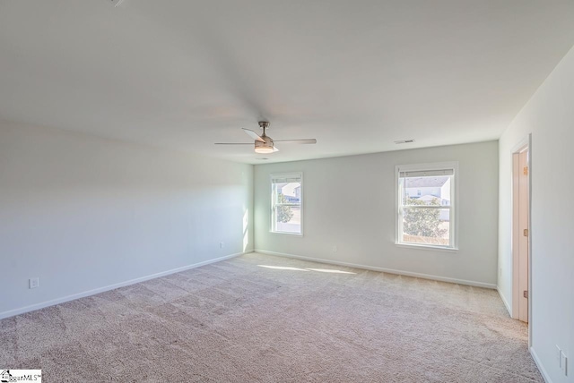 spare room with light carpet, baseboards, and a ceiling fan
