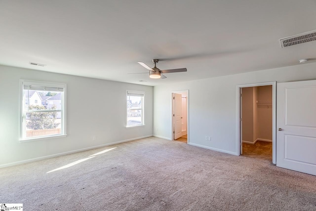 unfurnished bedroom featuring carpet flooring, visible vents, and multiple windows