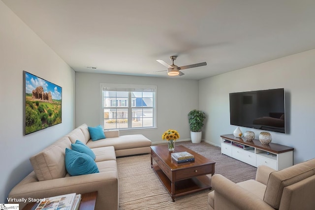 carpeted living room featuring visible vents, baseboards, and a ceiling fan