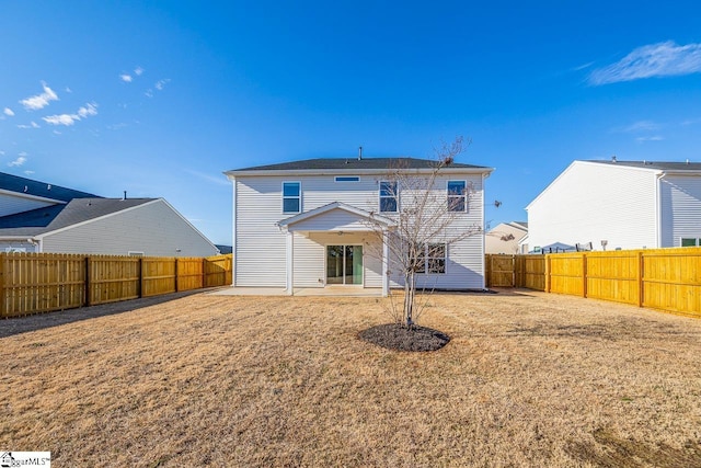 rear view of house with a fenced backyard and a patio area